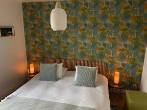 a bedroom with a bed with a blue and green wallpaper at La Majolique in Namur