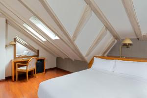 a bedroom with a bed and a desk and a mirror at Hotel de l'Isard in Andorra la Vella