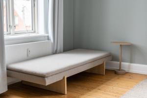 a bench sitting in a room next to a window at Perfect Holiday Homes Near Amager Beach in Copenhagen +92 photos