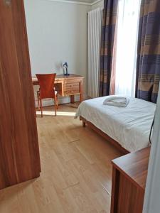 Schlafzimmer mit einem Bett, einem Schreibtisch und einem Stuhl in der Unterkunft Beaumane Rooms in Caux sur Montreux