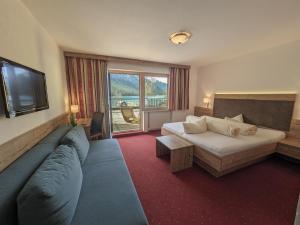 Habitación de hotel con cama y sofá en Hotel Forelle en Plansee