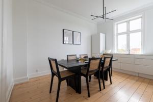 a dining room with a black table and chairs at Perfect Holiday Homes Near Amager Beach in Copenhagen