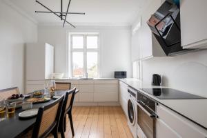 a kitchen with a table and chairs and a sink at Perfect Holiday Homes Near Amager Beach in Copenhagen