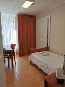 Schlafzimmer mit einem Bett, einem Tisch und einem Schreibtisch in der Unterkunft Beaumane Rooms in Caux sur Montreux
