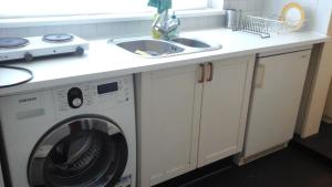 a kitchen counter with a washing machine and a sink at Studio 99 in Amsterdam