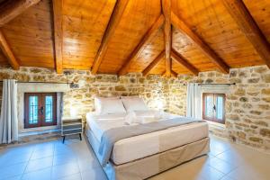 a bedroom with a large bed in a stone building at Mantineia Stone Villa-An Ethereal Getaway in Megáli Mandínia