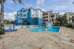 a swimming pool in front of a building at Pahali Kati 3 Bedroom Apartment in Nyali in Bamburi