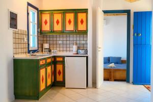 a kitchen with green cabinets and a white refrigerator at Cycladic Bliss - Uncovering Paros Seaview Gem in Drios