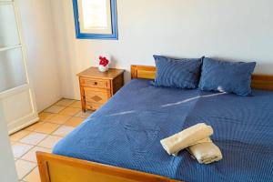 a bedroom with a blue bed with a blue comforter at Cycladic Bliss - Uncovering Paros Seaview Gem in Drios