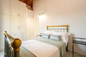 a bedroom with a bed with white and blue pillows at Mani Stone Built Home A breath Away to the Sea in Stoupa