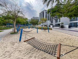 een strand met hangmatten in het zand in een stad bij Trophy - Dubai Hills Dreamy Delight Suite in Dubai