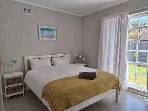 a bedroom with a bed with a bag on it at 4 Periwinkle Place in Cape Town