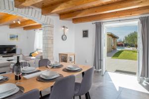 een eetkamer met een tafel en stoelen en een woonkamer bij Villa Bilinke by IstriaLux in Štokovci