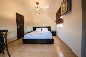 1 dormitorio con cama y lámpara de araña en Filiatra's Cozy Haven A Peaceful Escape in Nature, en Filiatra