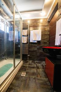 y baño con ducha acristalada y lavamanos. en Filiatra's Cozy Haven A Peaceful Escape in Nature, en Filiatra