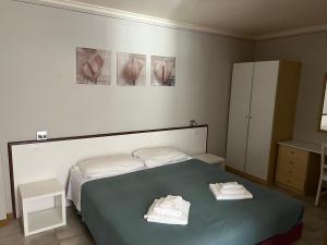 a bedroom with a bed with two towels on it at Hotel Lydia in Grado