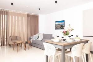 メーリッハにある2bed Flat W Shared Heated Pool In Mlh By Homely!のリビングルーム(テーブル、椅子、ソファ付)