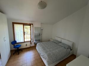 a bedroom with a bed and a chair and a window at Villetta relax alle porte di Milano in Rodano