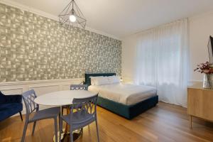 a bedroom with a bed and a table and chairs at Studio Stresa in Stresa