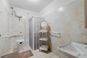a bathroom with a toilet and a mirror and a sink at Il Corbezzolo Apartment in Palmas Arborea