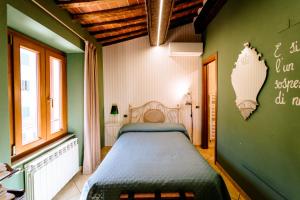 een slaapkamer met een bed en een groene muur bij B&B Da Nada Locanda Toscana in Roccatederighi