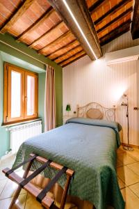 een slaapkamer met een groot bed en een groen dekbed bij B&B Da Nada Locanda Toscana in Roccatederighi