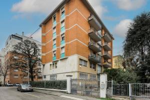 a tall brick building with a car parked in front of it at Magni2 in Bologna