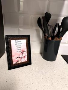 a black container of kitchen utensils next to a picture at Aries self-catering Unit in Centurion