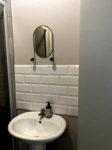 a bathroom with a white sink and a mirror at Aries self-catering Unit in Centurion