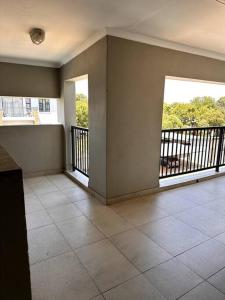 an empty room with a balcony with a view at Aries self-catering Unit in Centurion