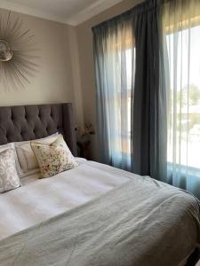 a bedroom with a bed with a large window at Aries self-catering Unit in Centurion