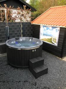 bañera de hidromasaje con escalones delante de una casa en Luxe gerenoveerde L-chalet en Putten