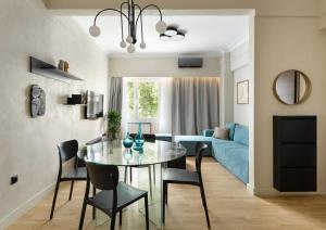 a dining room and living room with a glass table and chairs at Colors Hotel Athens in Athens