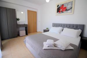 a bedroom with a large bed with towels on it at Afrimi Relax Apartments in Sarandë