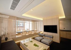a living room with a couch and a television at UH Suite Seoul Deoksugung in Seoul