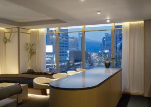 a living room with a table and a large window at UH Suite Seoul Deoksugung in Seoul