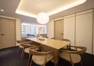 a dining room with a large wooden table and chairs at UH Suite Seoul Deoksugung in Seoul