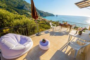 a balcony with a table and chairs and the ocean at Sandy Coast Hospitality in Agios Gordios