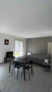 Cette chambre comprend un lit, une table, un lit et un canapé. dans l'établissement Studio Pivoine avec terrasse a proximité de Metz, à Metz