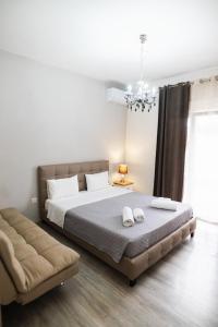 a bedroom with a large bed and a couch at HILI RESORT LUXURIOUS SEASIDE APARTMENT in Alexandroupoli