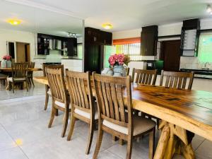 Un comedor con mesa y sillas de madera. en Khubonye Royal Guesthouse, en Randjesfontein