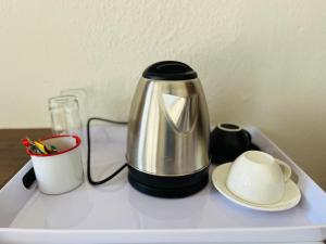 una cafetera y una taza en una bandeja en Khubonye Royal Guesthouse, en Randjesfontein