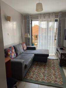 un salon avec un canapé et une fenêtre dans l'établissement CultureStays, à Kiambu 2 autres photos