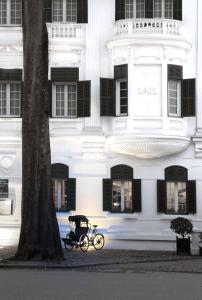 una bicicleta estacionada frente a un edificio blanco en Sofitel Legend Metropole Hanoi, en Hanói