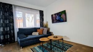 a living room with a blue couch and a table at FeWo Urban Gotha-Apartment Friedenstein- Am Schlosspark- Parken an der der Tür- Barrierefrei, 900 Meter zum Bahnhof - Wallbox in Gotha