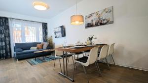 a living room with a dining room table and a couch at FeWo Urban Gotha-Apartment Friedenstein- Am Schlosspark- Parken an der der Tür- Barrierefrei, 900 Meter zum Bahnhof - Wallbox in Gotha