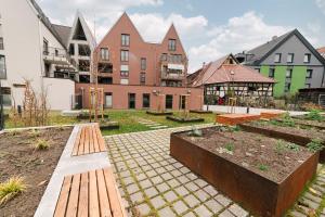 um jardim com bancos num pátio com edifícios em ZENtrahome - Balkon Outlet Zentral SmartTV Business em Metzingen