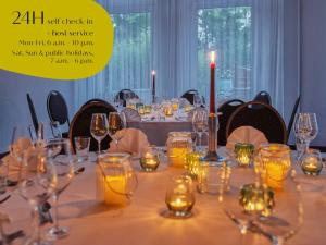 a table with wine glasses and candles on it at Classik Hotel Magdeburg in Magdeburg