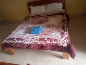 Bett mit einer roten und weißen Bettdecke in der Unterkunft Prudent Guest House in Isuvya