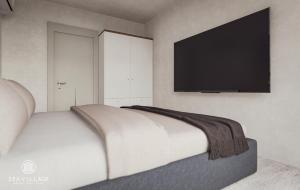 a bedroom with a bed with a flat screen tv on the wall at SeaVillage in Năvodari